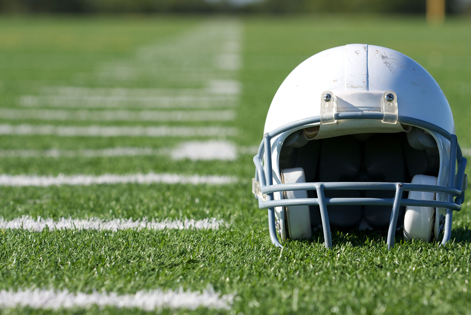 Close-up of a lone helmet on a football field